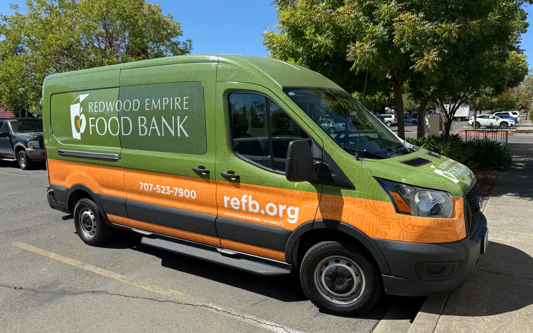 a company vehicle wrapped with a vinyl graphics showing company details